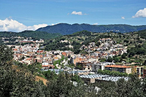 Panoramic view of the town with houses and mountains.
