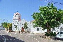 Dorfplatz mit weißer Kirche und großem Baum in Benitagla.