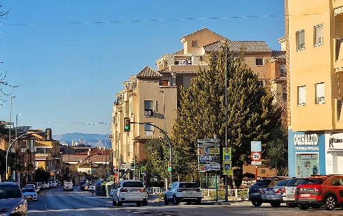 Straße mit Autos und Wohngebäuden in Ogíjares, Granada.