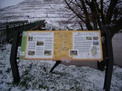 Cartel informativo del Camino de Santiago en Tardajos con paisaje nevado.