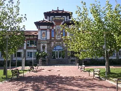 Viticulture congress palace in Villava with decorative details and a garden in front.