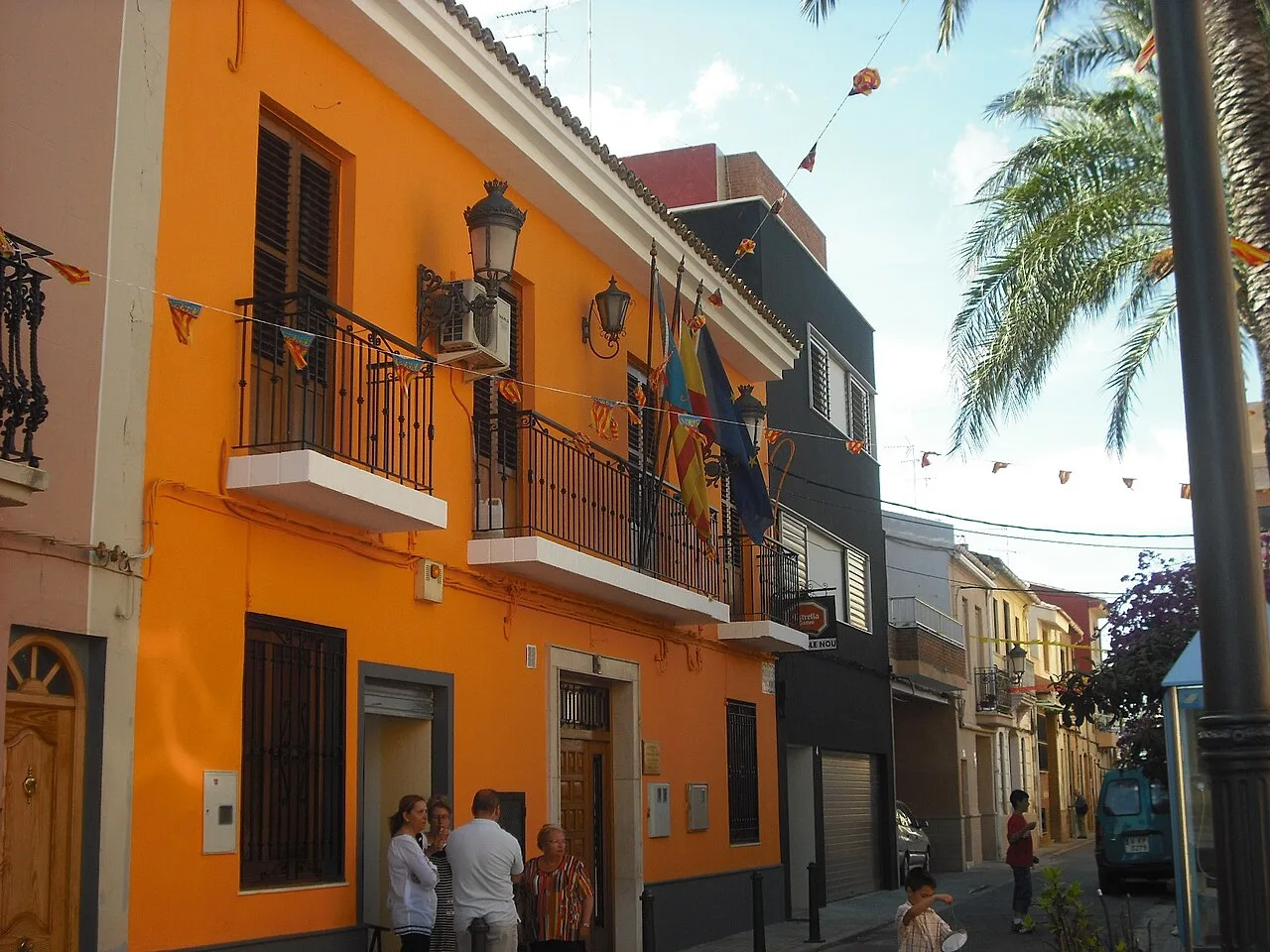 Oranges Rathausgebäude mit Balkonen und Flaggen in Lugar Nuevo de la Corona.