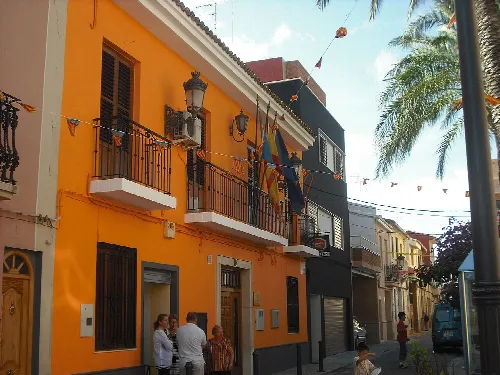 Oranges Rathausgebäude mit Balkonen und Flaggen in Lugar Nuevo de la Corona.
