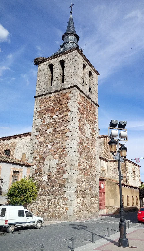 Stone tower with bell tower and pointed roof in Navalmanzano.