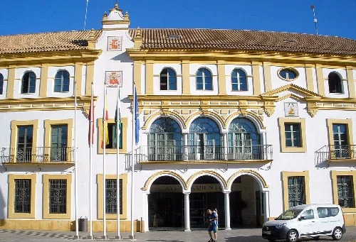 Town hall building with flags in the main square.