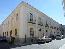 Gelbes Gebäude mit Bogenfenstern an einer Straße in Peñaranda de Bracamonte.