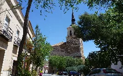 Iglesia antigua con torre y árboles en Santa Cruz de Mudela.