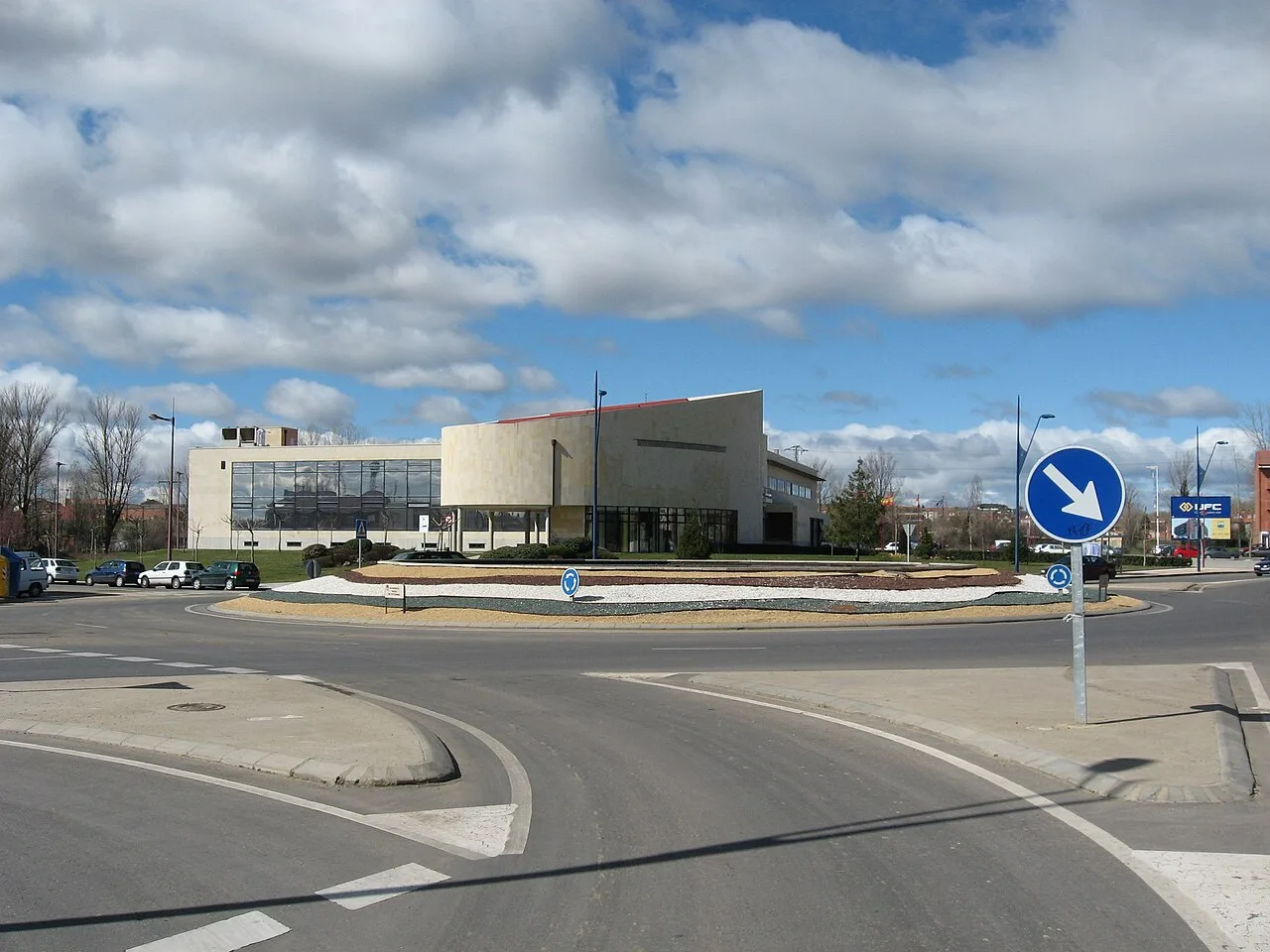 Modern town hall building in a roundabout with traffic signs.