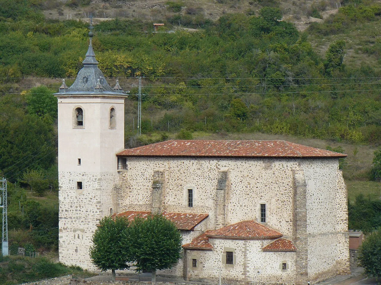 Iglesia con torre y tejado de tejas rojas en Villanueva de Cameros.
