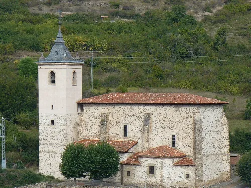 Iglesia con torre y tejado de tejas rojas en Villanueva de Cameros.