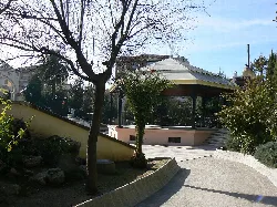 Music kiosk in La Encina Park, surrounded by trees and gardens.
