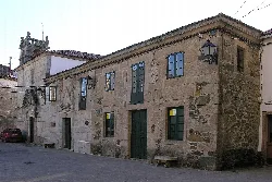 Edificio de piedra con ventanas y faroles en Mellid, La Coruña.