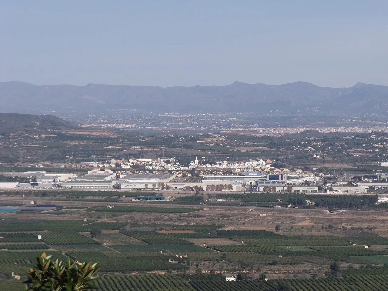 Paisaje agrícola con campos y urbanización en Loriguilla, Valencia.
