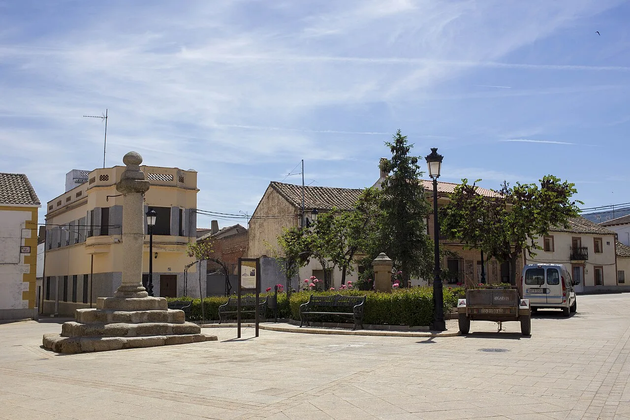 Plaza del Rollo with fountain, benches, and trees in Espinoso del Rey.