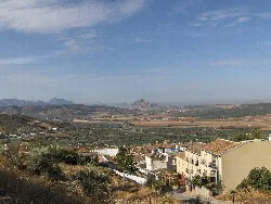 Vista de la Vega de Archidona con montañas y casas en primer plano.