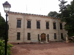 Fachada de un edificio antiguo con ventanas y puerta de madera en Petrer.