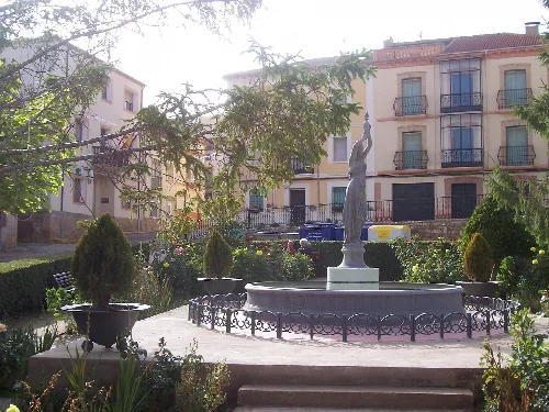 Garten auf dem Hauptplatz von Serón de Nágima mit Brunnen und Skulptur.