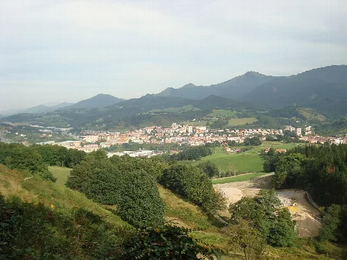 Panoramablick auf Andoáin mit Bergen und Vegetation.