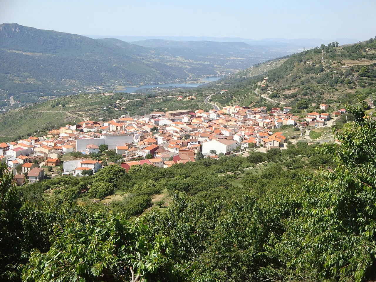 Vista panorámica de un pueblo en un valle rodeado de colinas verdes.