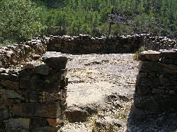 Petroglyphen in Las Hurdes, mit Steinmauern und Vegetation.