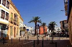Plaza with palm trees and colorful buildings in Santa Marta de los Barros.