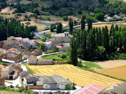Paisaje de Corrales de Duero con iglesia y campos agrícolas.