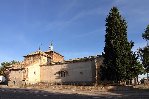 Iglesia con un árbol grande y cielo azul en Villamiel de Toledo.