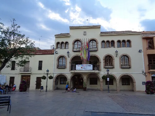 Rathaus von La Eliana mit Flaggen und Menschen auf dem Platz.