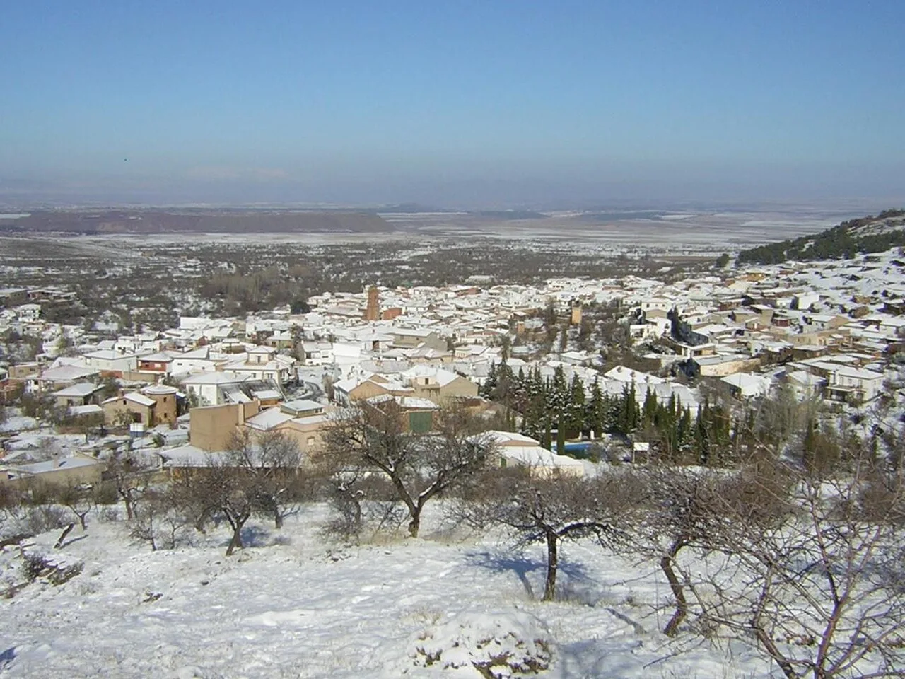 Blick auf Aldeire mit schneebedeckten Häusern im Winter.