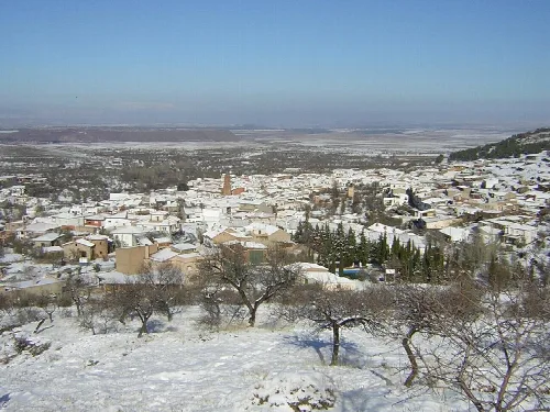 Blick auf Aldeire mit schneebedeckten Häusern im Winter.