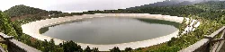 Runder Stausee mit ruhigem Wasser und umliegender Vegetation in Barlovento.