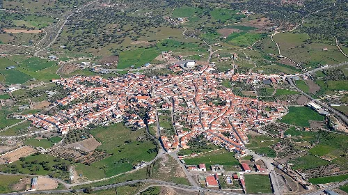 Luftaufnahme von Pedroche mit Straßen und Gebäuden im Zentrum und grünen Flächen drumherum.