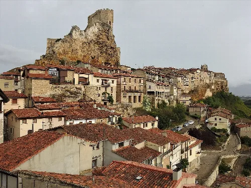 View of houses and a castle on a hilltop in Frías.
