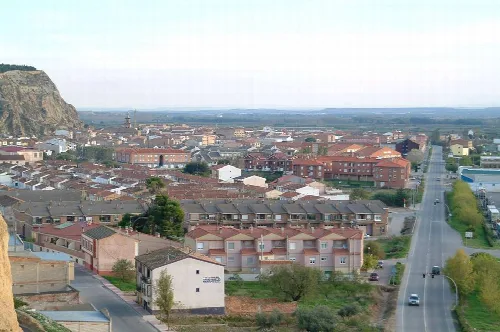 Panoramic view of Azagra with houses, streets, and a hill in the background.