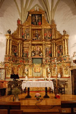 Golden altarpiece with religious scenes and figures in Lazagurría church.