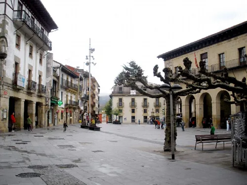 Platz in Oiartzun mit geschnittenen Bäumen und historischen Gebäuden