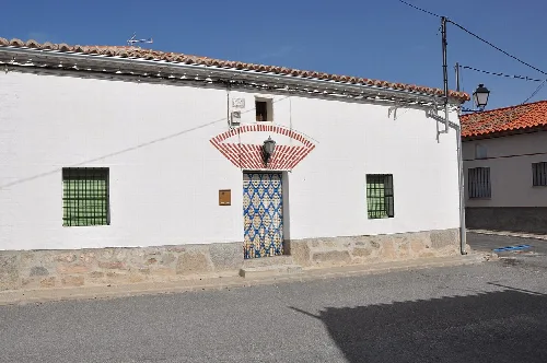 Weißes Haus mit dekorierter Tür und grünen Gitterfenstern in Villaflor.