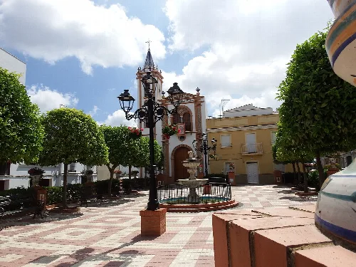 Platz mit Bäumen, Laternen und Brunnen in Bonares.