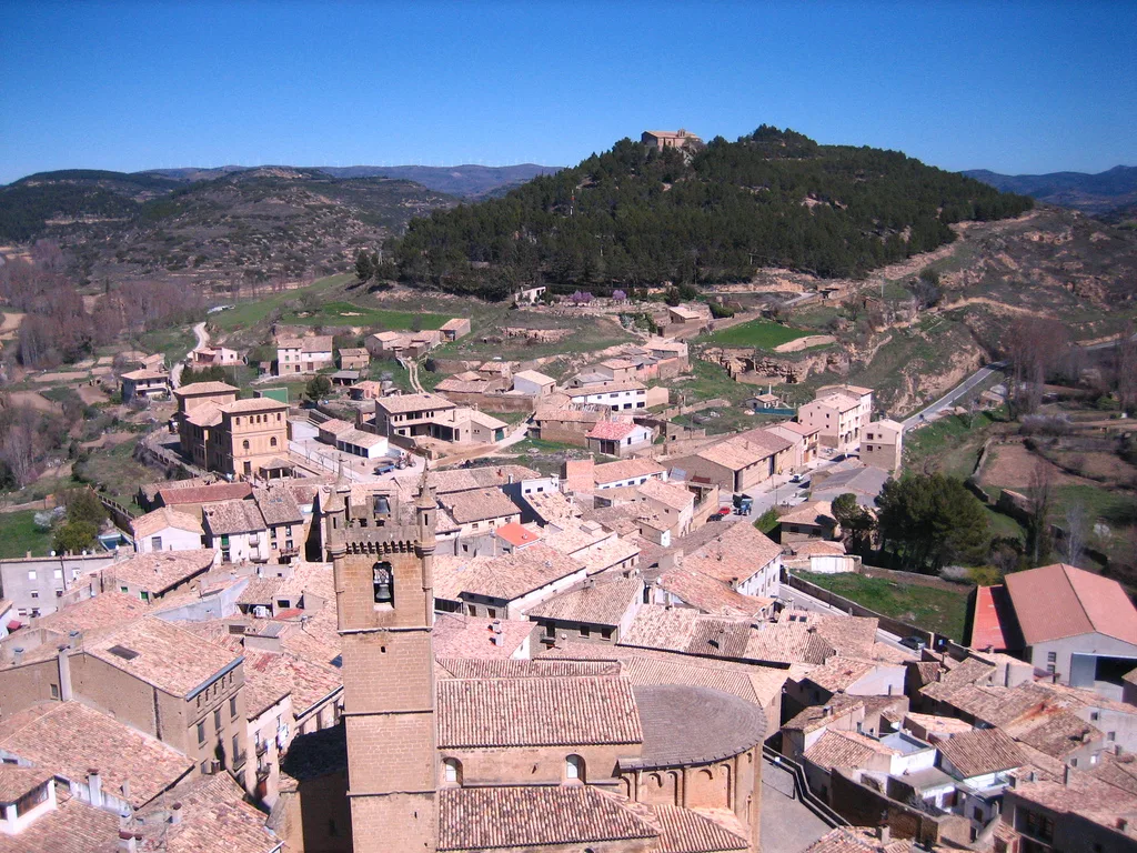 Vista aérea de Uncastillo con casas y un castillo en la colina.
