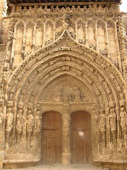 Facade of a church with Gothic arch and sculptures at the entrance