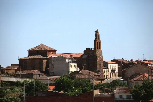 Kirche von Santovenia mit Turm und roten Ziegeldächern.