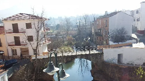 Génave-Brücke über einen Fluss mit Häusern und Bäumen in Jaén.