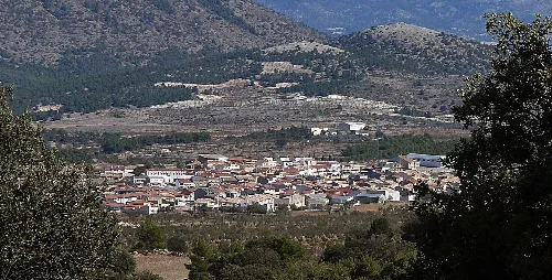 Vista panorámica de un pueblo en un valle rodeado de montañas.