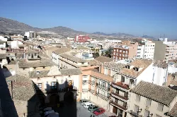 Panoramic city view with buildings and mountains in the background.
