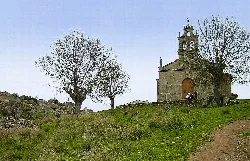Hermitage in Pereña de la Ribera with trees and a nearby path.