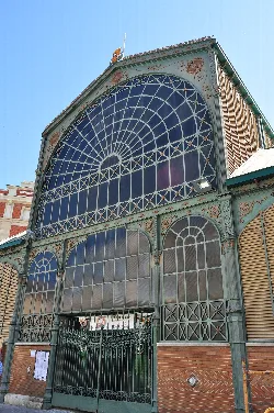 Edificio de mercado con estructura de hierro y grandes ventanas de cristal en Palencia.