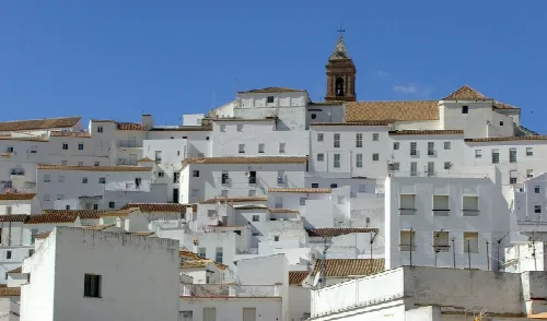 Weiße Gebäude mit Ziegeldächern und einer Kirche in der Mitte in Alcalá de los Gazules.