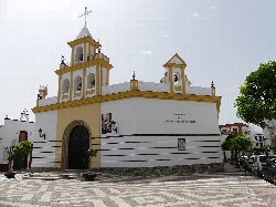 Church with white facade and yellow details in Los Palacios y Villafranca.