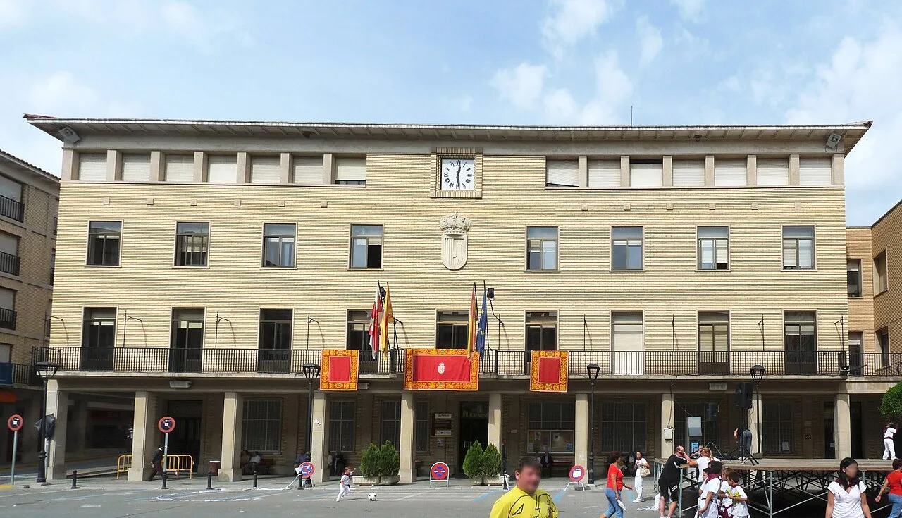 Edificio del ayuntamiento de Tauste con banderas en la fachada.