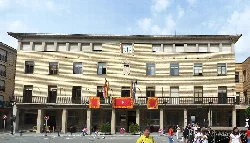 Edificio del ayuntamiento de Tauste con banderas en la fachada.